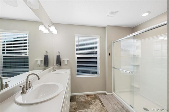full bathroom featuring baseboards, a shower stall, and a sink