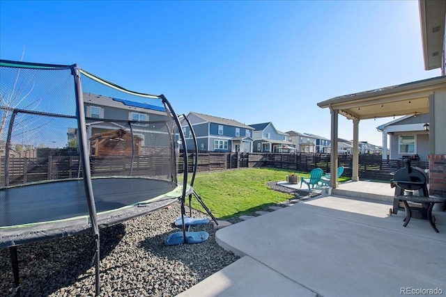 view of patio / terrace featuring a residential view, a fenced backyard, and a trampoline