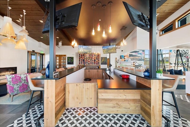 bar with wooden ceiling, a wealth of natural light, and a towering ceiling
