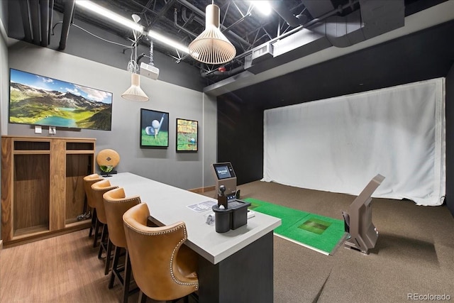 rec room with wood finished floors and a towering ceiling