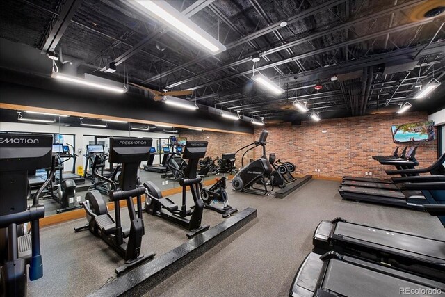 exercise room featuring brick wall