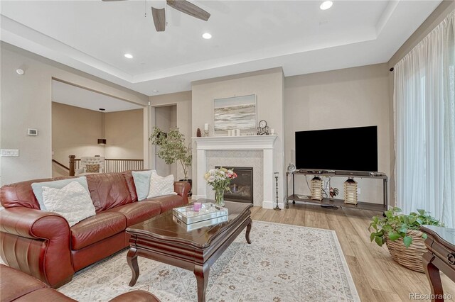 2932 Eagle Wing Way, Castle Rock, CO 80109 - living room with wood finished floors, ceiling fan, recessed lighting, a raised ceiling, and a glass covered fireplace