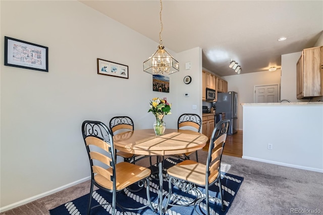 carpeted dining space featuring an inviting chandelier