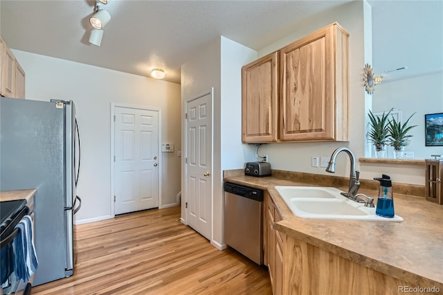 kitchen featuring sink, stainless steel appliances, light hardwood / wood-style floors, and light brown cabinets