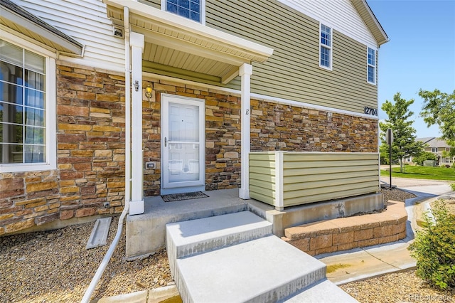 12704 Jasmine St Unit E, Thornton, CO 80602 - doorway to property with stone siding and covered porch
