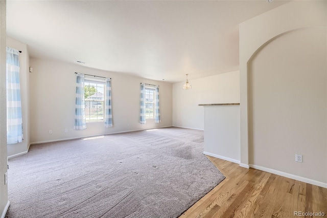 12704 Jasmine St Unit E, Thornton, CO 80602 - empty room featuring a chandelier and light wood-style flooring