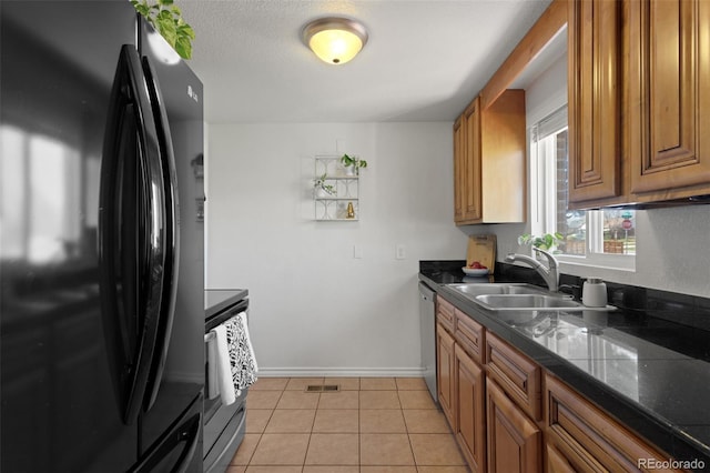 3300 Oneida St, Denver, CO 80207 - kitchen featuring brown cabinetry, appliances with stainless steel finishes, dark countertops, a sink, and light tile patterned flooring