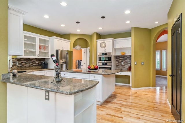 7 Sandpiper Cir, Thornton, CO 80241 - kitchen with arched walkways, open shelves, appliances with stainless steel finishes, decorative backsplash, and recessed lighting