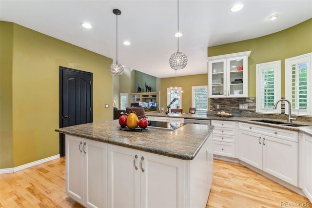 7 Sandpiper Cir, Thornton, CO 80241 - kitchen featuring light wood-style floors, glass insert cabinets, white cabinets, hanging light fixtures, and recessed lighting
