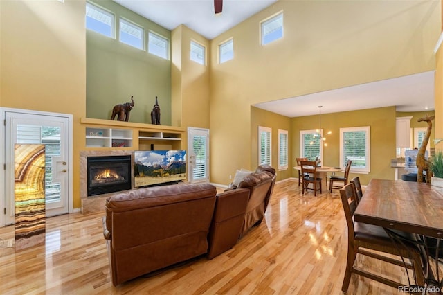 7 Sandpiper Cir, Thornton, CO 80241 - living area with light wood-type flooring, a high ceiling, a premium fireplace, and a ceiling fan