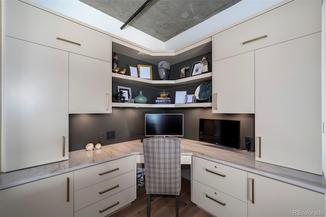 home office featuring dark hardwood / wood-style floors and built in desk