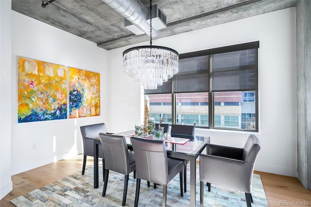 dining space featuring hardwood / wood-style floors and a chandelier