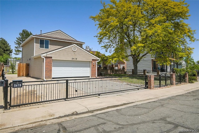 5419 E 113th Ave, Thornton, CO 80233 - view of front facade featuring brick siding, driveway, and a gate