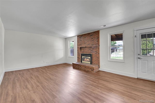 5419 E 113th Ave, Thornton, CO 80233 - unfurnished living room featuring wood finished floors, baseboards, and a brick fireplace