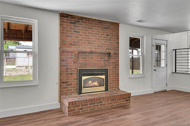 5419 E 113th Ave, Thornton, CO 80233 - unfurnished living room with wood finished floors, baseboards, and a brick fireplace