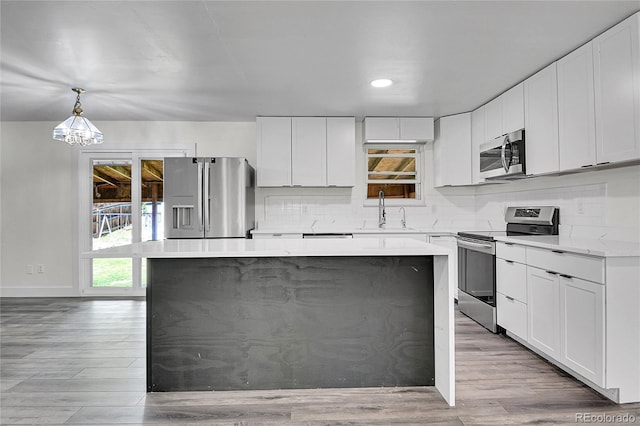 5419 E 113th Ave, Thornton, CO 80233 - kitchen featuring appliances with stainless steel finishes, a sink, a kitchen island, light wood-style floors, and recessed lighting