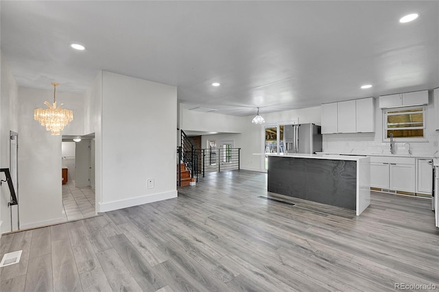 5419 E 113th Ave, Thornton, CO 80233 - kitchen featuring a chandelier, stainless steel fridge with ice dispenser, light countertops, a kitchen island, and recessed lighting