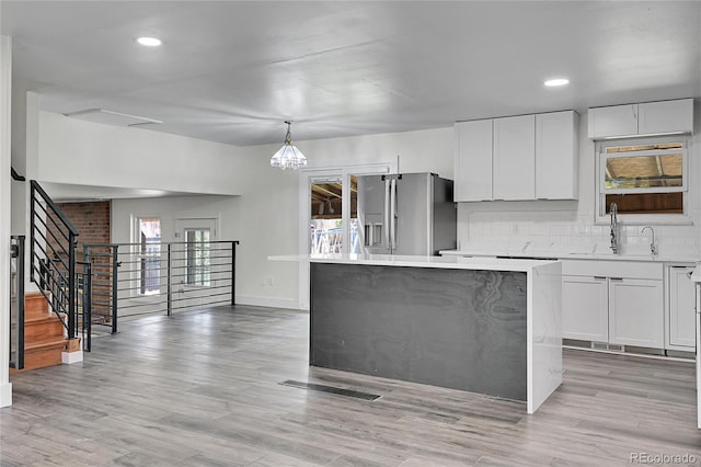 5419 E 113th Ave, Thornton, CO 80233 - kitchen featuring a sink, stainless steel fridge, light countertops, a kitchen island, and white cabinetry