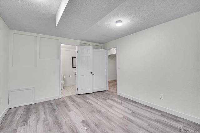5419 E 113th Ave, Thornton, CO 80233 - unfurnished bedroom with a textured ceiling, wood finished floors, connected bathroom, and baseboards
