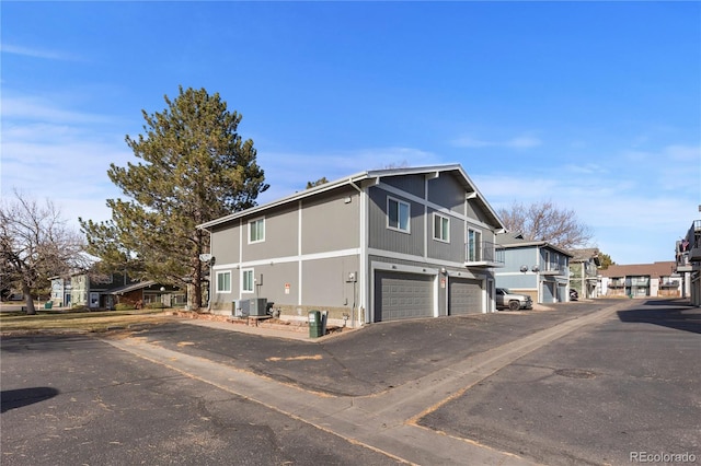 view of side of property with central AC unit and a garage