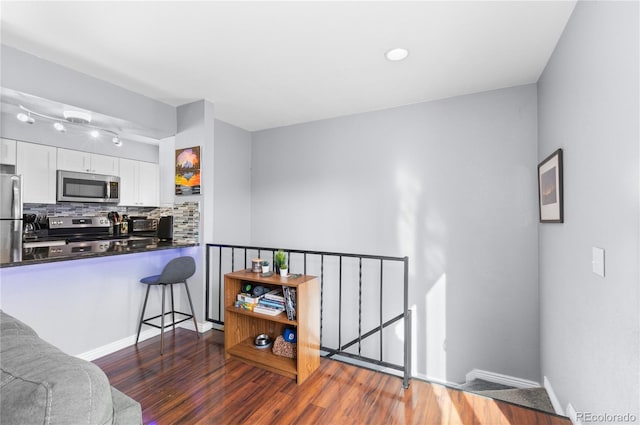 kitchen featuring backsplash, white cabinetry, dark wood-type flooring, and stainless steel appliances