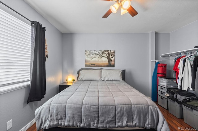 bedroom with multiple windows, ceiling fan, and hardwood / wood-style flooring