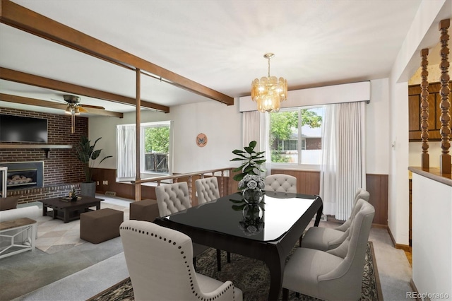 352 S Peoria Cir, Aurora, CO 80012 - dining space with a ceiling fan, a wainscoted wall, a chandelier, beam ceiling, and a fireplace