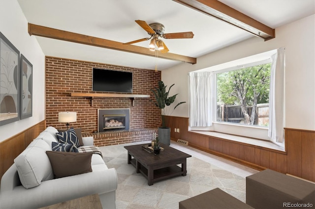 352 S Peoria Cir, Aurora, CO 80012 - living room with wainscoting, beamed ceiling, wood walls, a brick fireplace, and a ceiling fan