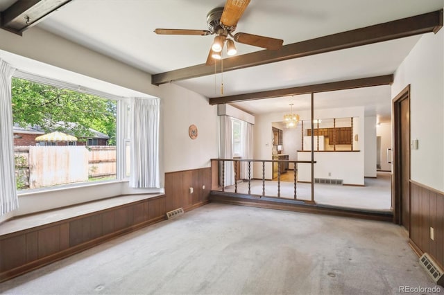 352 S Peoria Cir, Aurora, CO 80012 - unfurnished living room with carpet floors, beam ceiling, wood walls, a wainscoted wall, and ceiling fan
