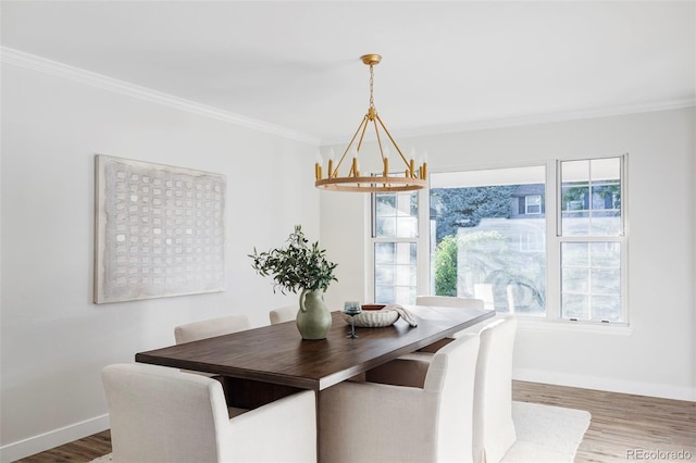 dining space featuring hardwood / wood-style floors, a chandelier, and crown molding