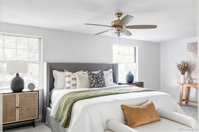 carpeted bedroom featuring ceiling fan and multiple windows