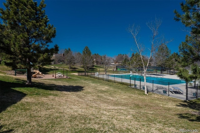 view of community featuring a lawn and a swimming pool