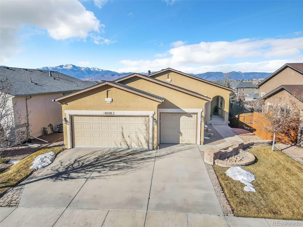 6038 Cumbre Vista Way, Colorado Springs, CO 80924 - ranch-style home with a garage, concrete driveway, a mountain view, and stucco siding