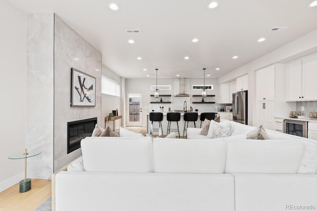2040 W 45th Ave, Denver, CO 80211 - living area featuring wine cooler, recessed lighting, a tile fireplace, and light wood finished floors
