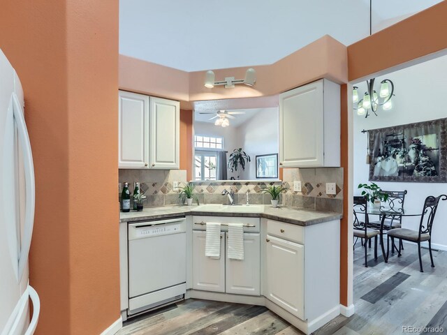 kitchen with white appliances, sink, ceiling fan, decorative backsplash, and white cabinetry