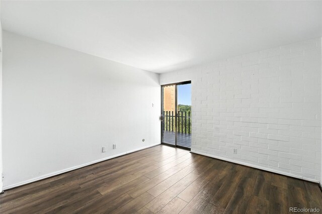 460 S Marion Pkwy Unit 801, Denver, CO 80209 - unfurnished room featuring dark wood finished floors and brick wall