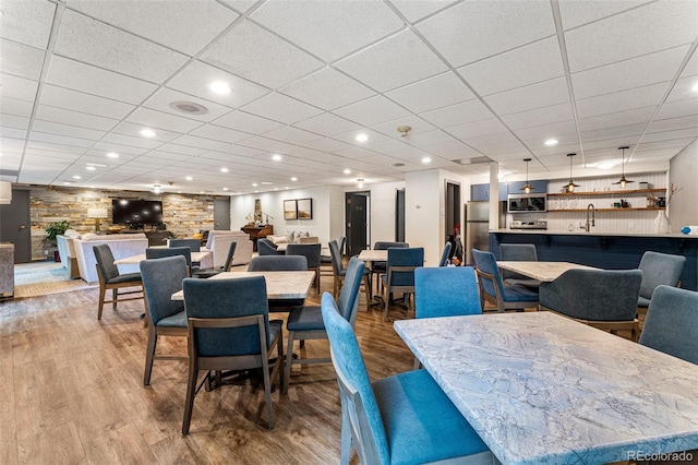 460 S Marion Pkwy Unit 801, Denver, CO 80209 - dining space featuring wood finished floors, a paneled ceiling, a community bar, and recessed lighting