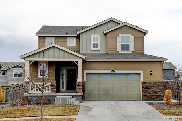 craftsman-style home featuring a porch, a garage, fence, concrete driveway, and board and batten siding