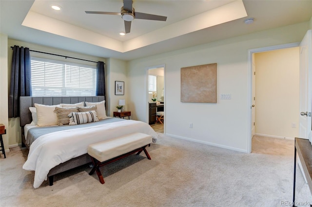 bedroom featuring light carpet, recessed lighting, a raised ceiling, and baseboards