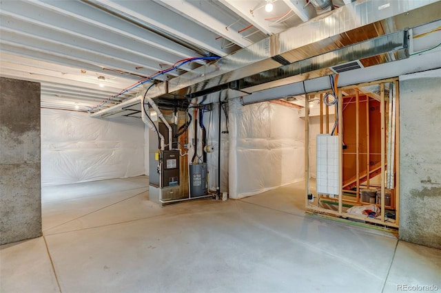 unfinished basement with water heater, visible vents, and heating unit