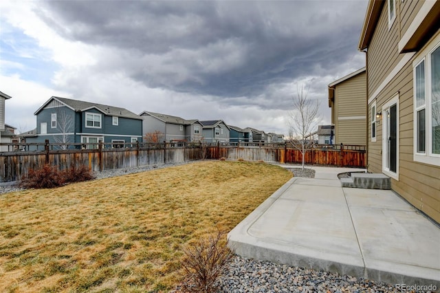 view of yard with a patio area, a fenced backyard, and a residential view