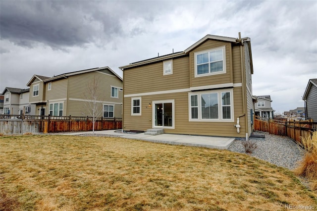 rear view of house featuring a yard, a patio area, and a fenced backyard