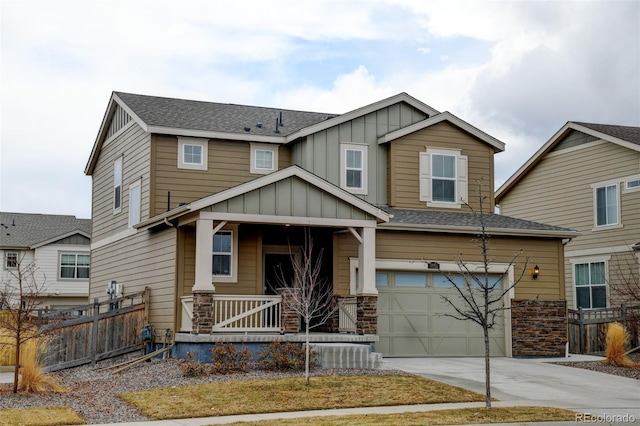 craftsman-style home with driveway, a garage, covered porch, fence, and board and batten siding