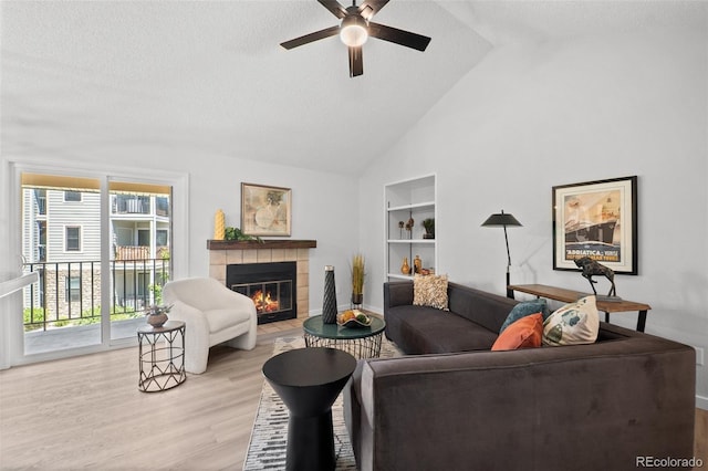 6755 S Field St Unit 625, Littleton, CO 80128 - living room with ceiling fan, a fireplace, light wood-style flooring, a textured ceiling, and high vaulted ceiling