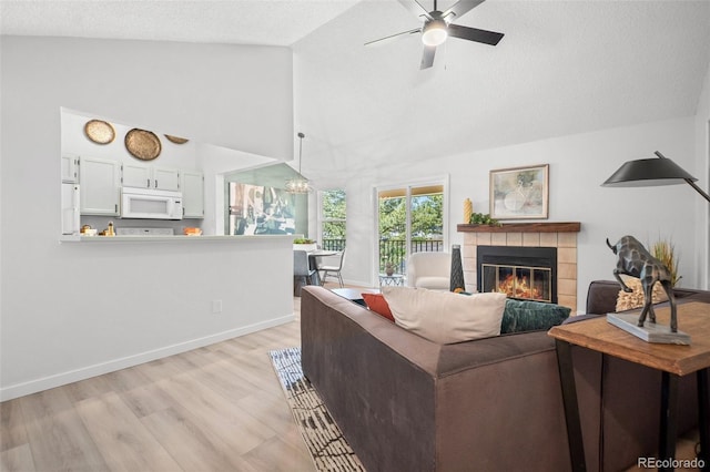 6755 S Field St Unit 625, Littleton, CO 80128 - living room with a fireplace, light wood-style flooring, high vaulted ceiling, ceiling fan, and baseboards