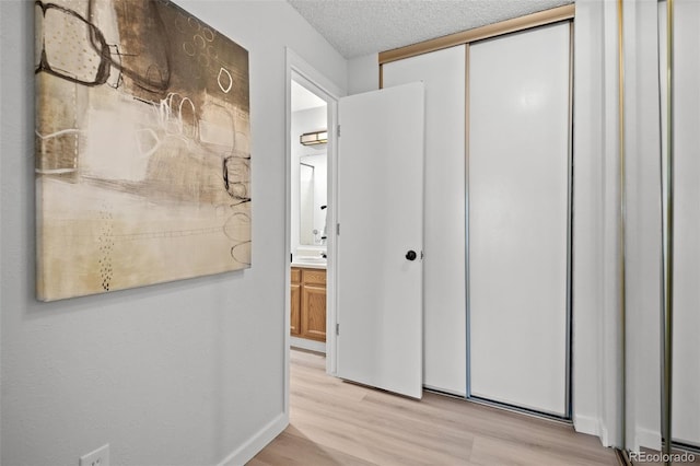 6755 S Field St Unit 625, Littleton, CO 80128 - hall featuring light wood-type flooring, a textured ceiling, and baseboards