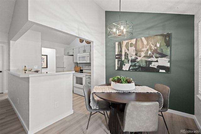 6755 S Field St Unit 625, Littleton, CO 80128 - dining room with vaulted ceiling, a chandelier, light wood-type flooring, and baseboards