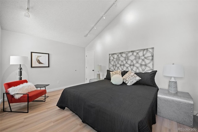 6755 S Field St Unit 625, Littleton, CO 80128 - bedroom with track lighting, light wood finished floors, baseboards, and vaulted ceiling