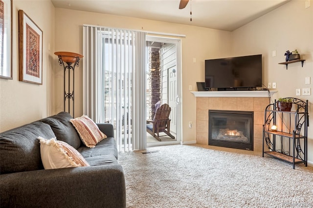 carpeted living room with ceiling fan and a fireplace