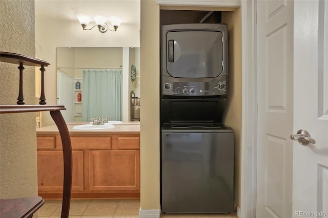 bathroom featuring stacked washer and clothes dryer, tile patterned floors, and vanity